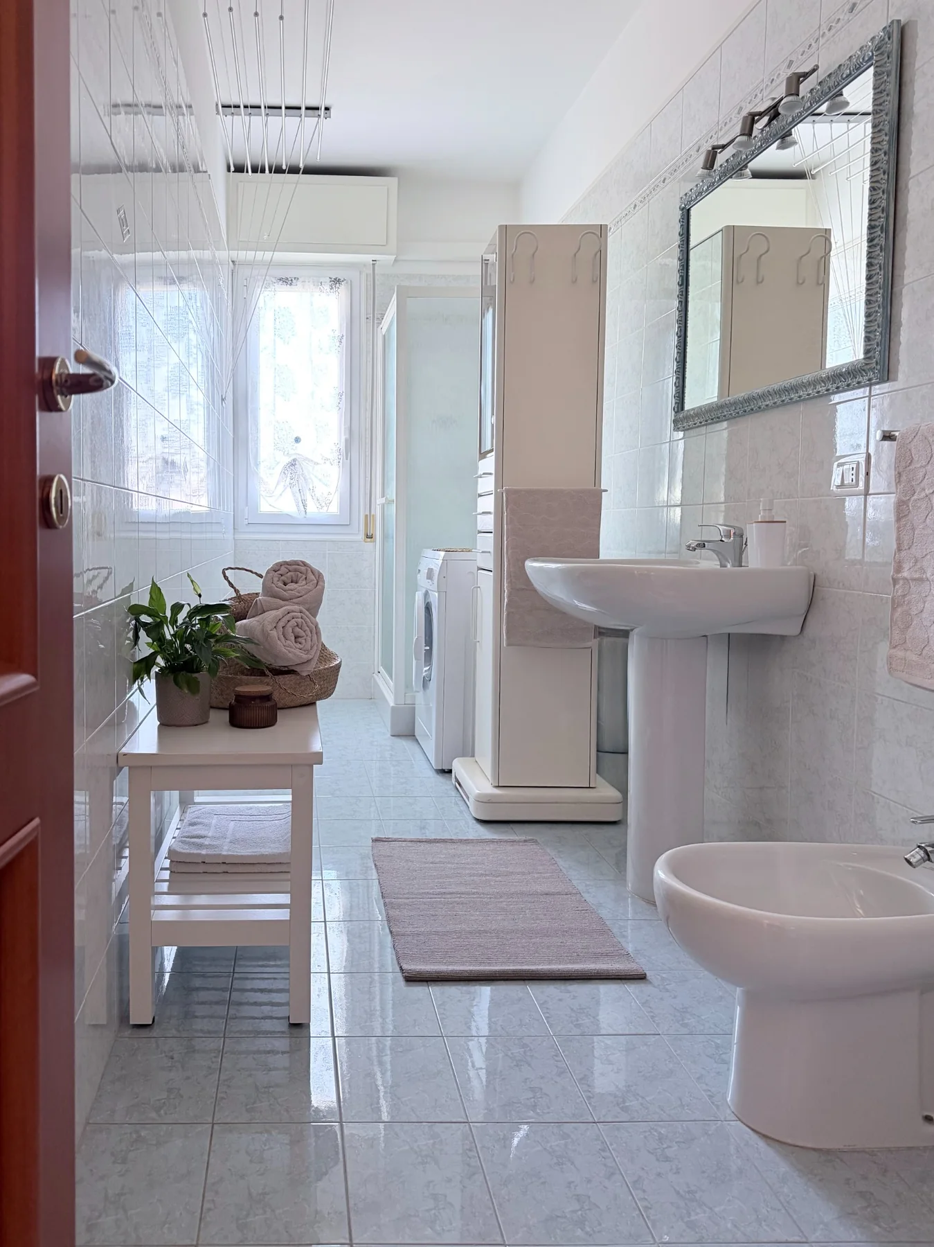 Bagno luminoso con lavabo, bidet e doccia